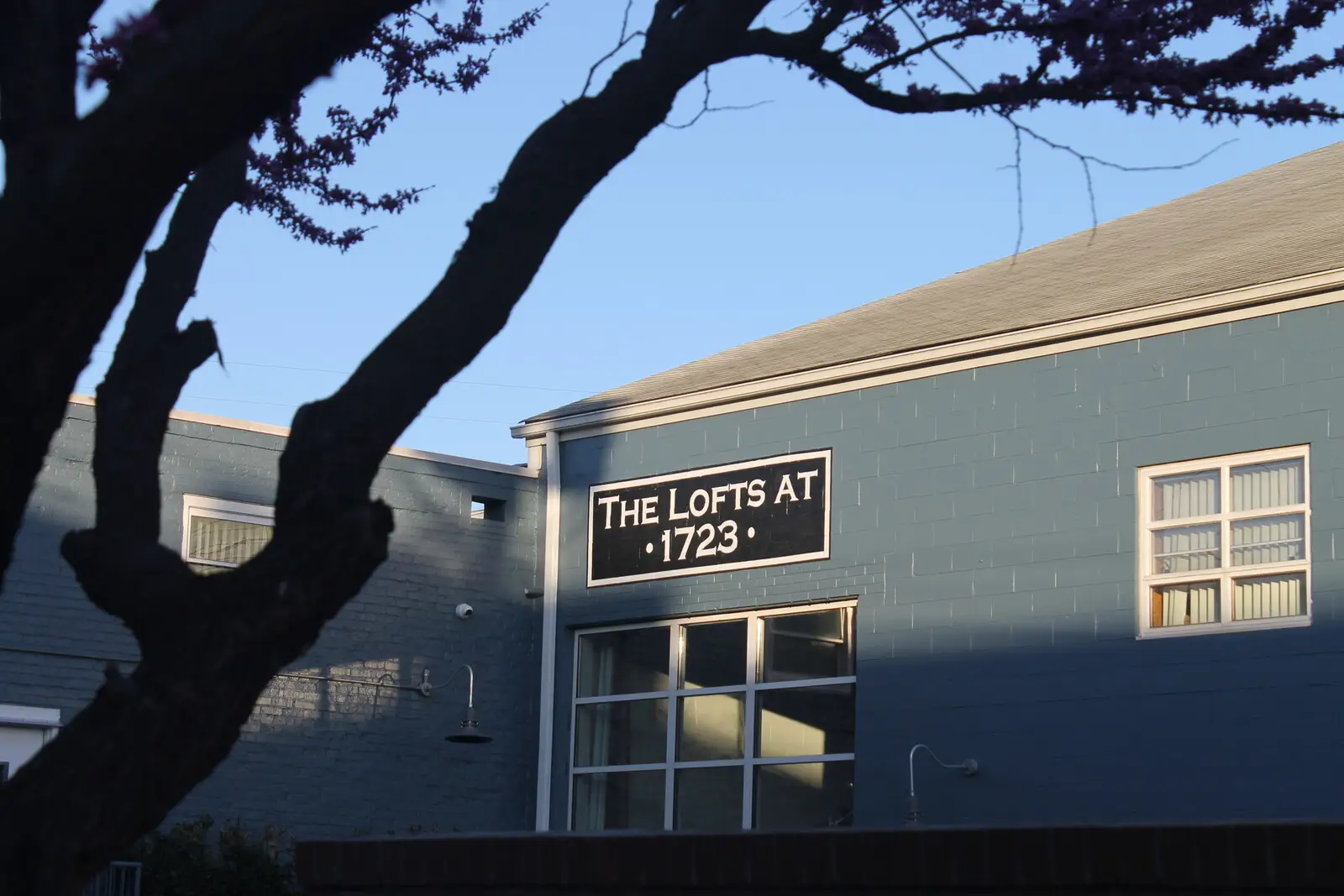 The Lofts at 1723 — the converted blue industrial building in Scott’s Addition, its name lettered above the entrance.