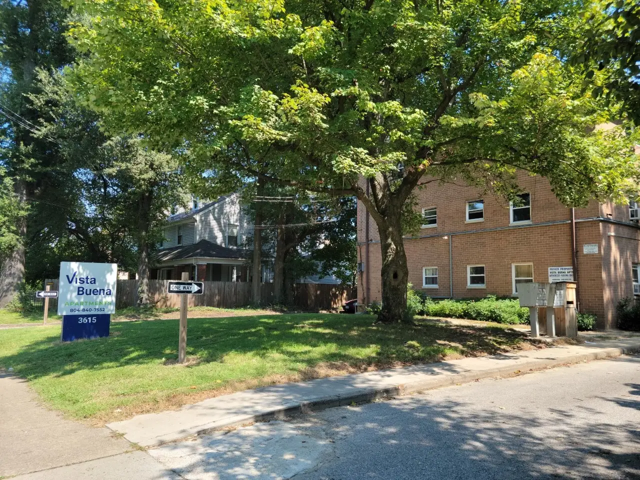 Vista Buena Apartments in Richmond’s Ginter Park neighborhood, a brick building set back behind mature trees.